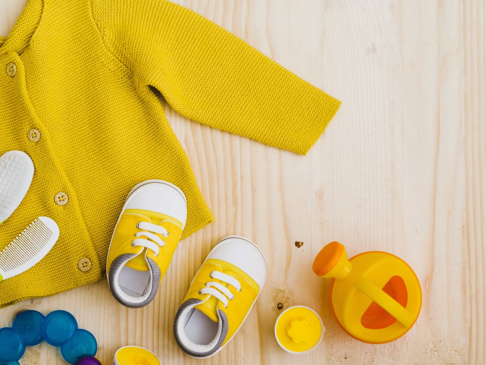 top-view-yellow-sweater-with-toys-min